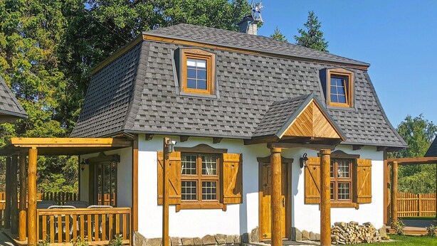 A traditional house with a steeply pitched roof, wooden shutters, and a small porch with a wooden railing. - Nice home in Kopalino with WiFi (Kopalino)