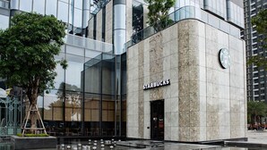 Una tienda Starbucks con fachada de vidrio moderna y exterior con textura de piedra.
