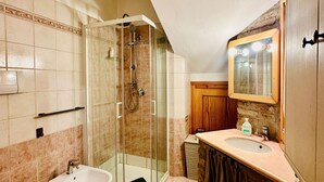 A bathroom with a glass-enclosed shower, a sink, and a mirror. - San Pancrazio Home - Treviso (Treviso)