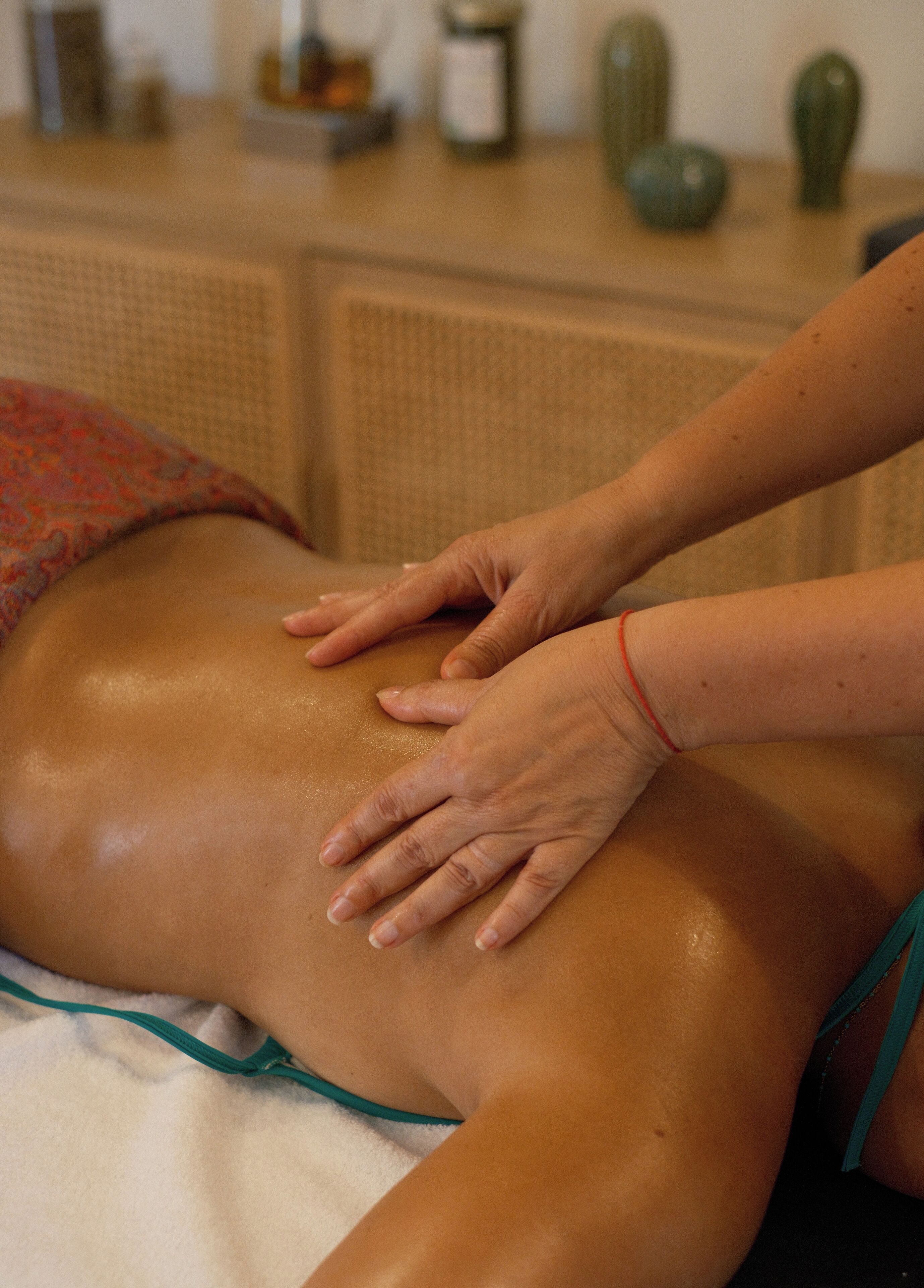 Une séance de massage est en cours sur une table de massage.