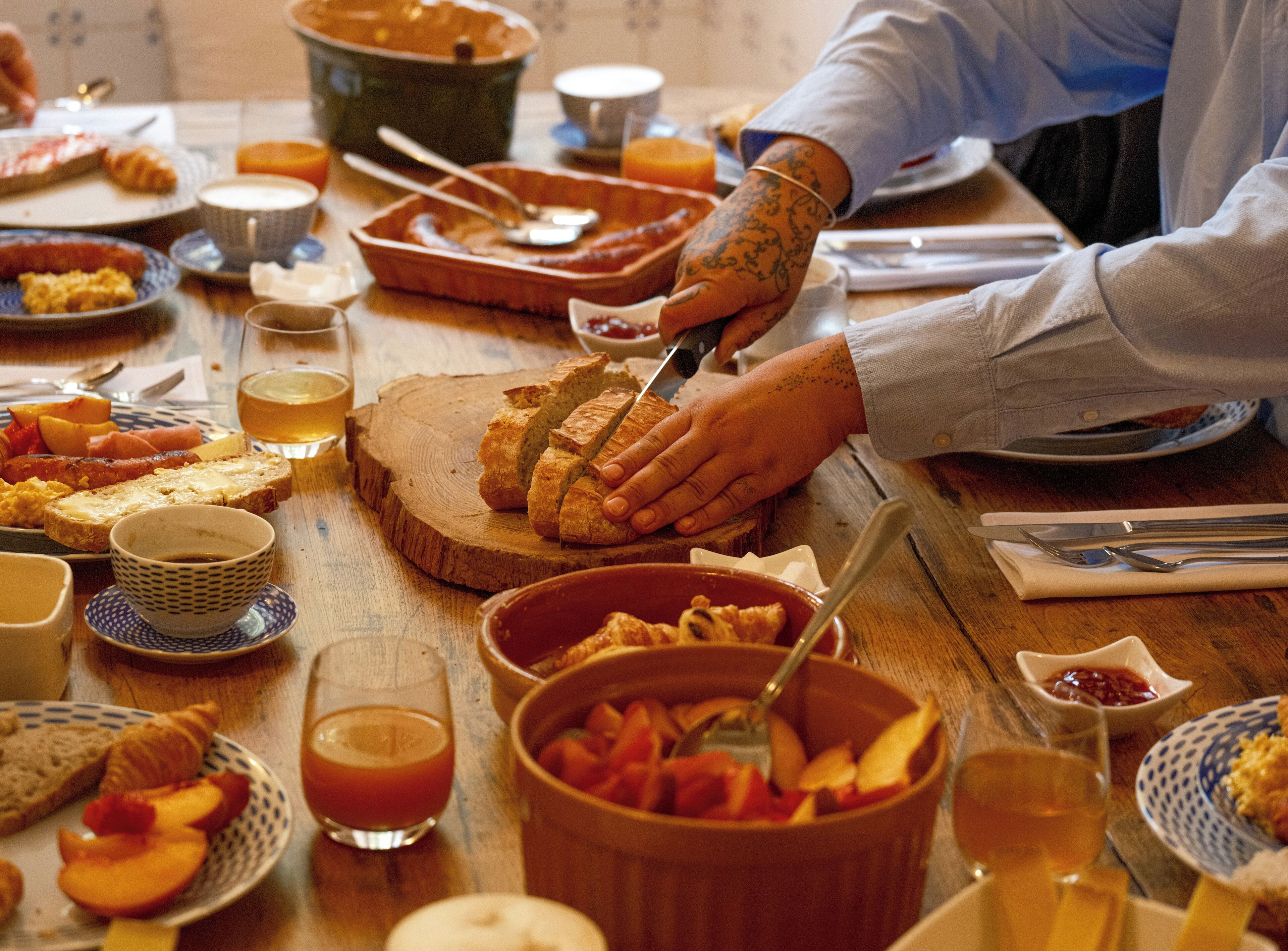 Une table de petit-déjeuner avec divers aliments et ustensiles.
