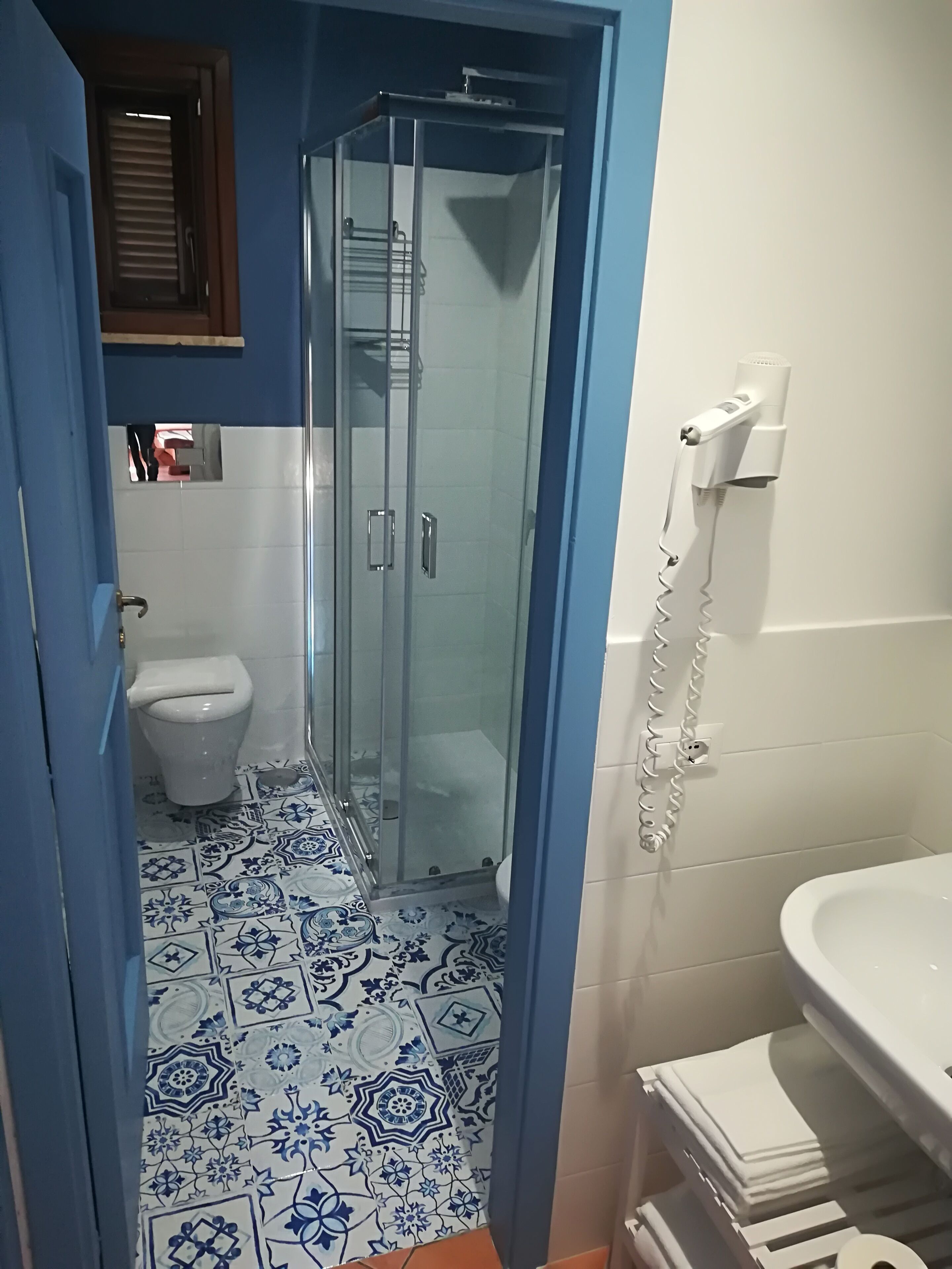 A bathroom with a shower, toilet, and sink.