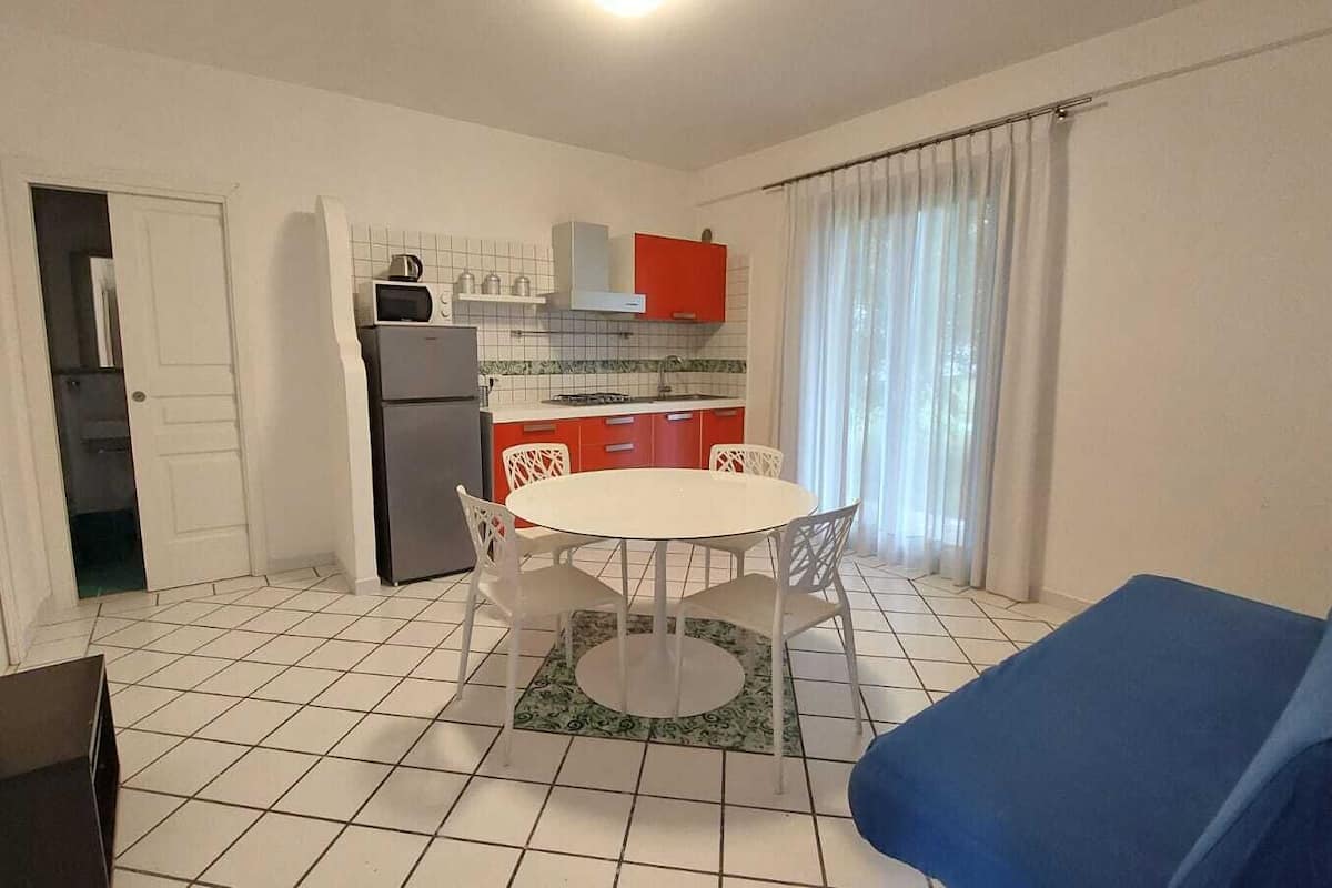 Un espace de vie compact comprenant une cuisine, un coin repas et un canapé.