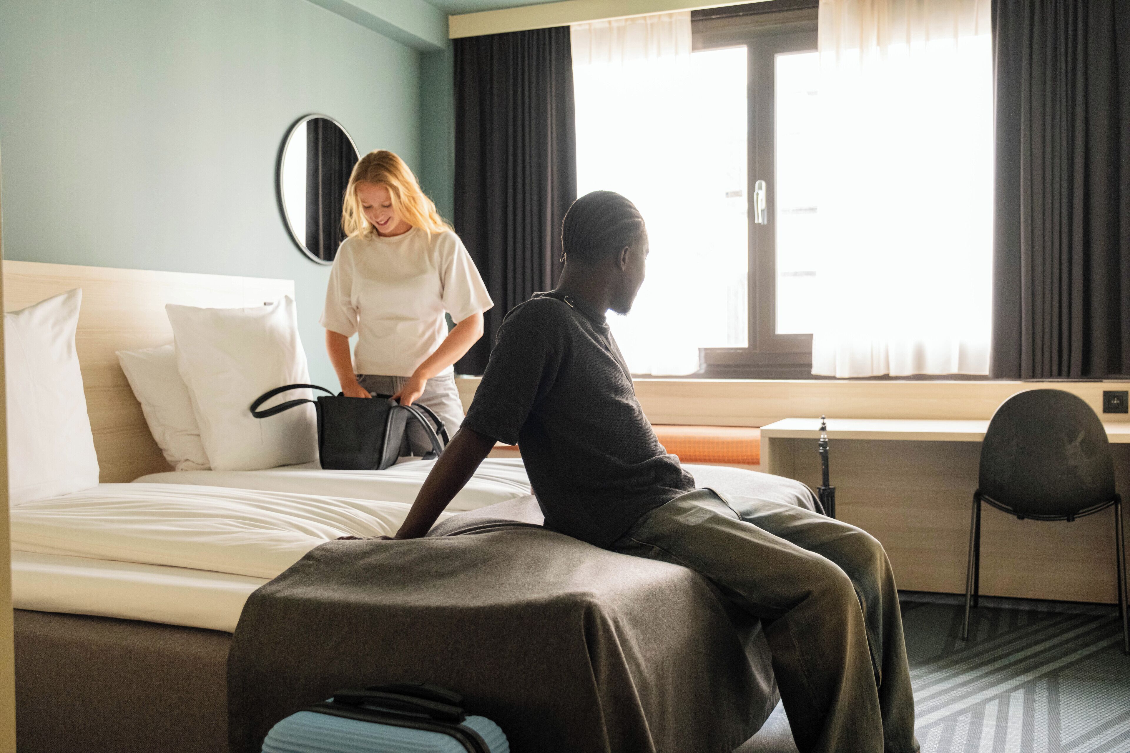 Une chambre d’hôtel avec un lit, un bureau et une chaise.