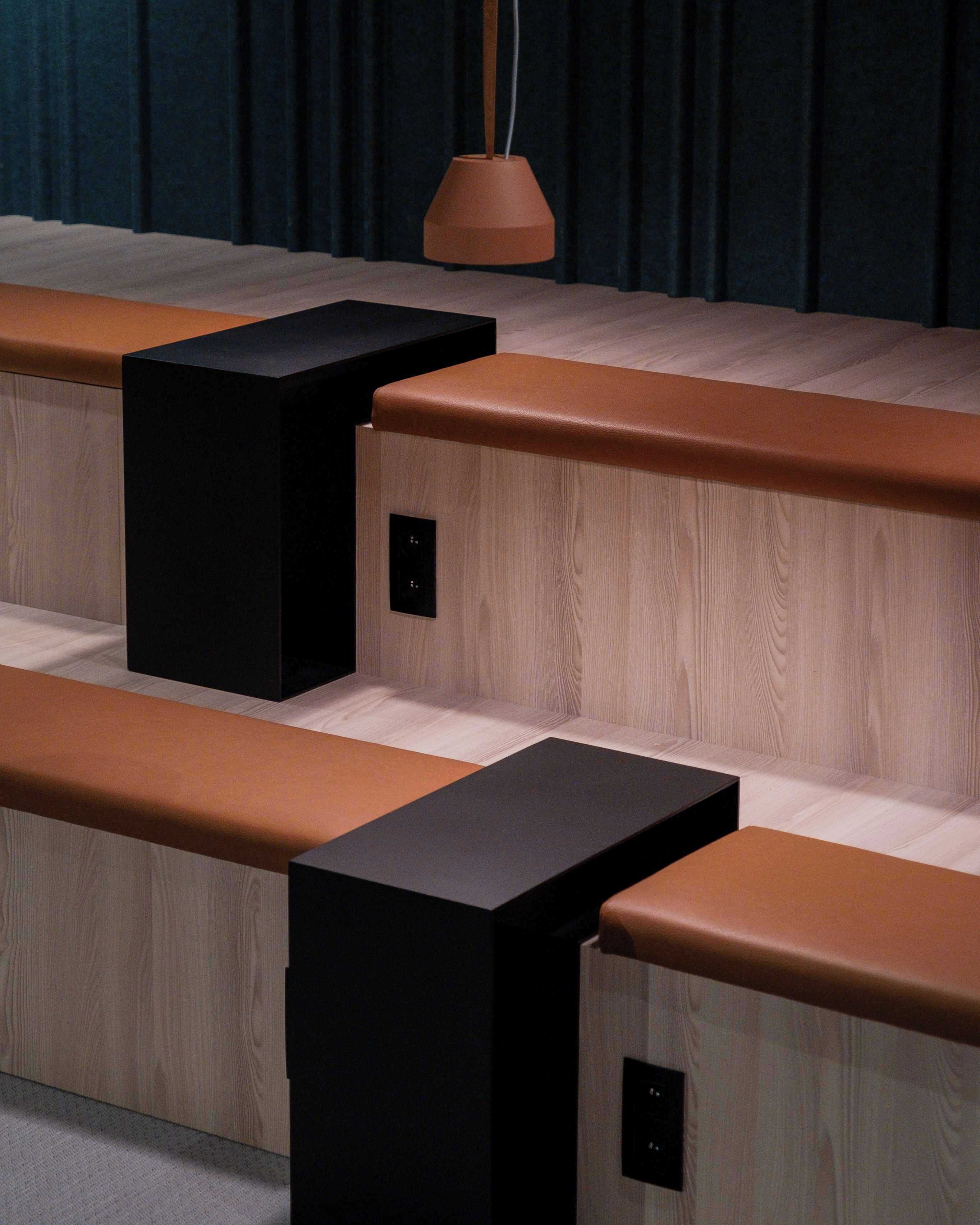 A modern seating area with wooden benches and black square blocks.