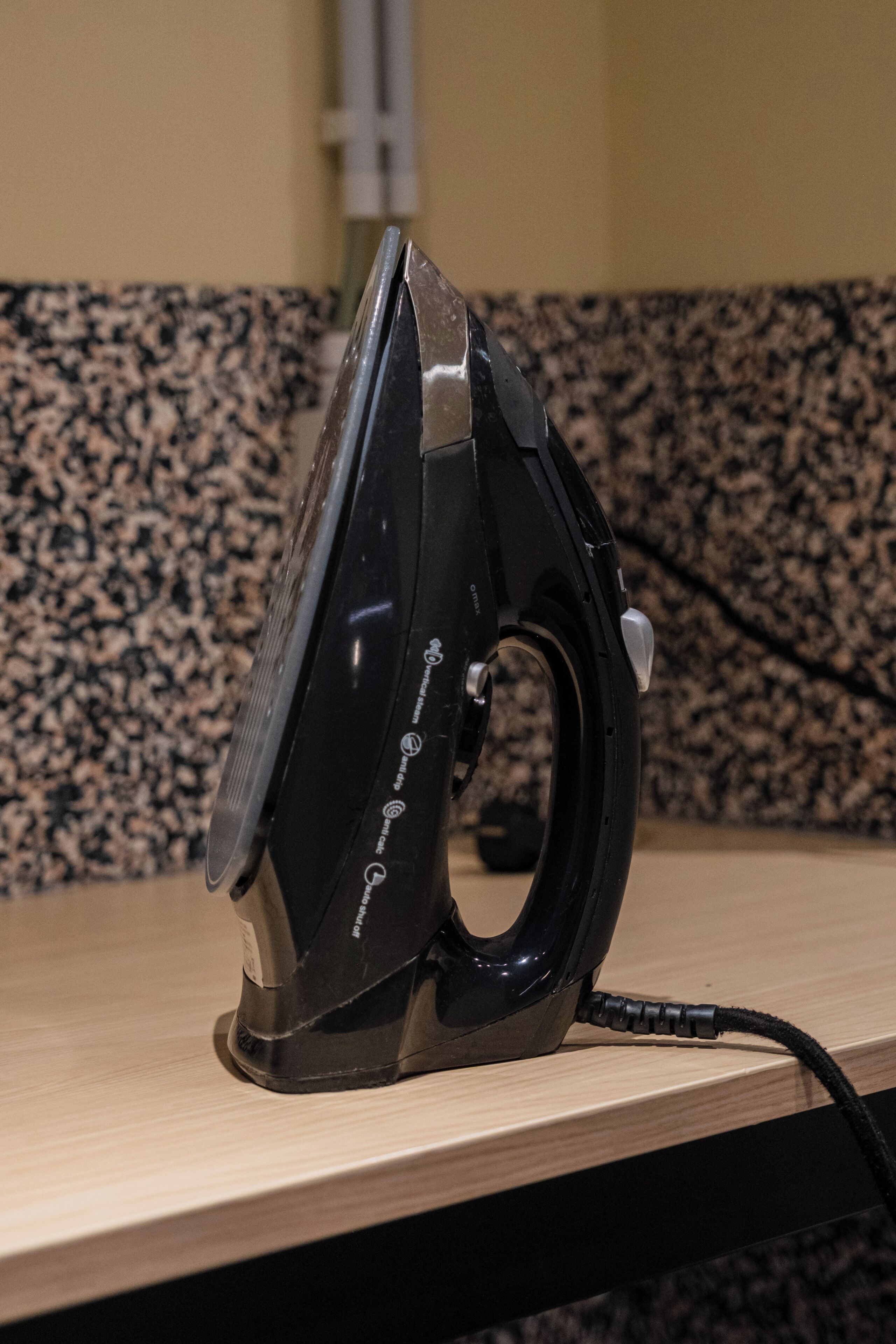Un electrodoméstico de hierro negro sobre una superficie de madera, con un salpicadero de granito al fondo.