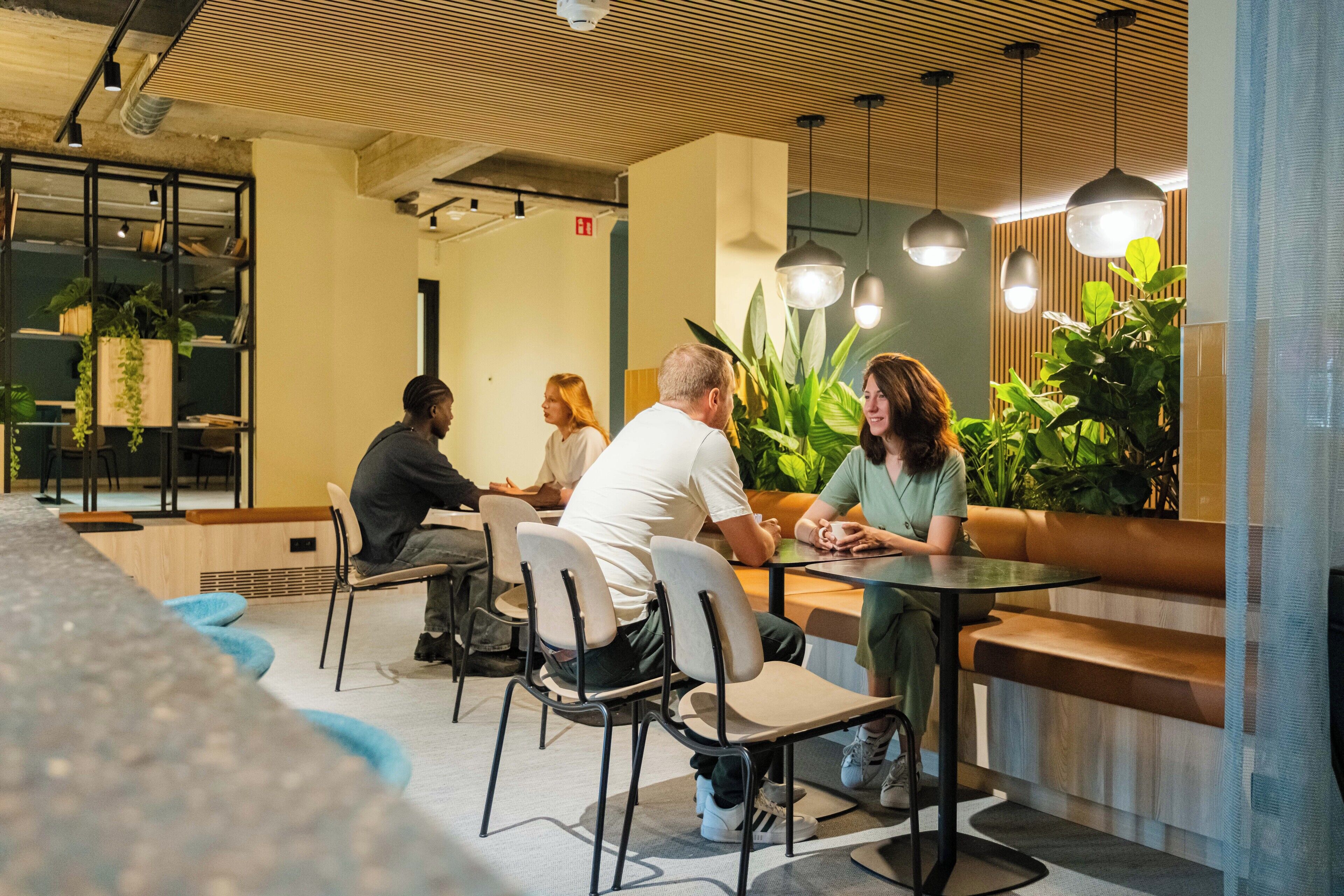 A modern indoor space with seating arrangements and hanging lights.