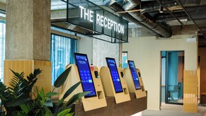 A reception area with a digital kiosk, a sign reading "THE RECEPTION", and a plant to the left. - Citybox Brussels Centre Louise (Brussels)