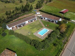 Relax in a serene courtyard with a swimming pool and shaded seating areas surrounded by lush greenery.
