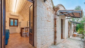 Un edificio de piedra con interior de madera, un comedor y un patio de piedra.