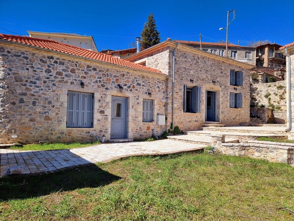 A stone building with a red-tiled roof, a small front porch, and a staircase leading to the entrance. - Stone Suites & Villas by Open City Hotel (Tripoli)