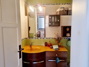 A bathroom with a wooden vanity, a mirror, and a sink. - Stone Suites & Villas by Open City Hotel (Tripoli)
