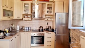 Una cocina con vigas de madera, un refrigerador de acero inoxidable, un horno y diversos electrodomésticos.