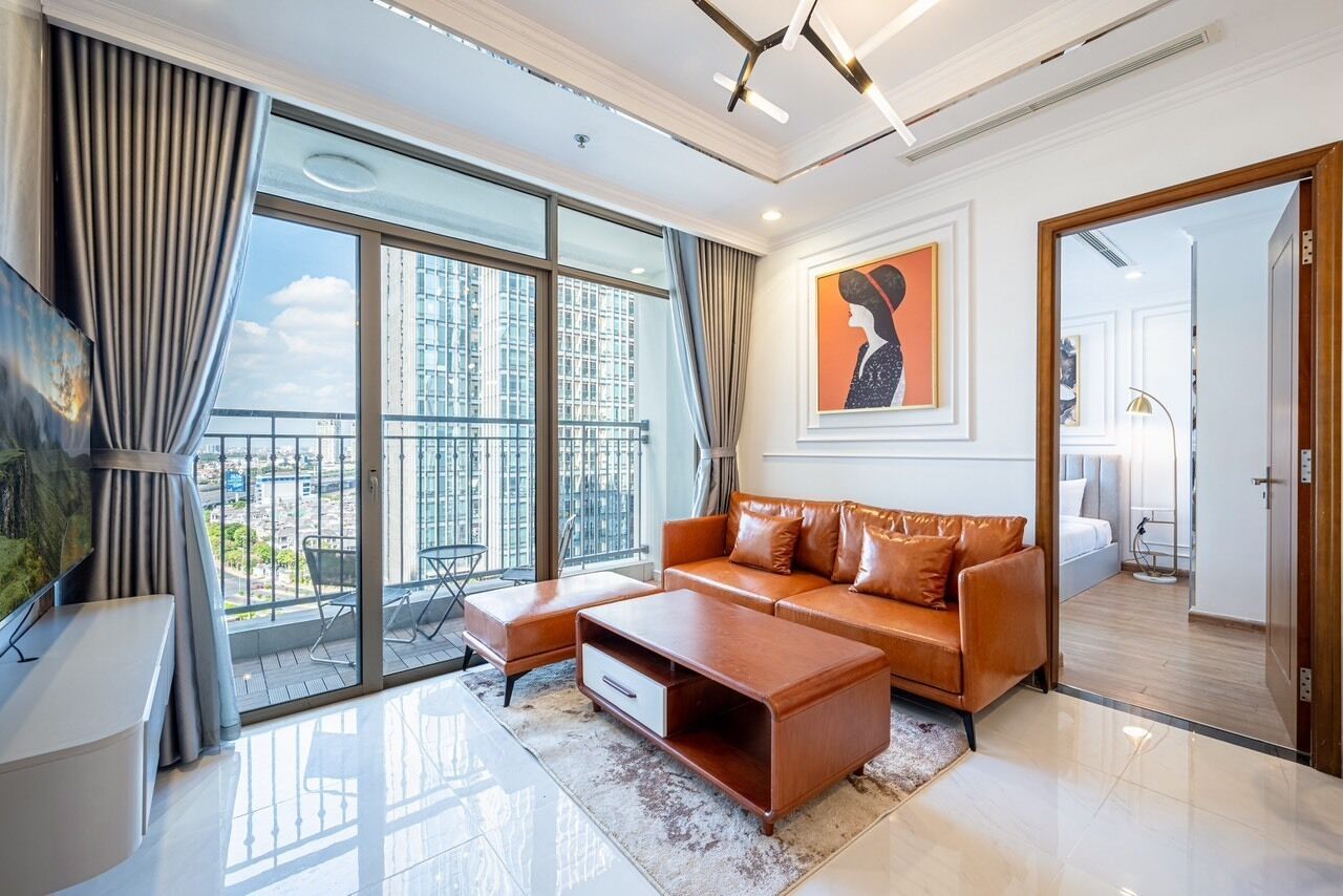 A modern living room with a large window, a sofa, a coffee table, and a TV.