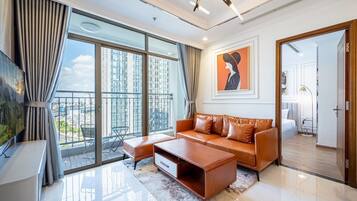 A modern living room with a large window, a sofa, a coffee table, and a TV.