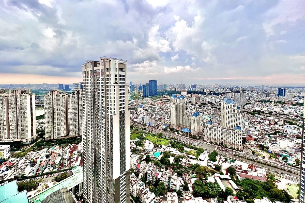 A high-rise building with a modern architectural design, surrounded by a densely populated urban area with various buildings and infrastructure.