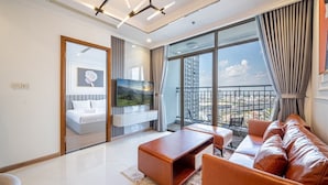 A modern living room with a sofa, coffee table, and TV. - SaigonHomes in Vinhomes Central Park (Ho Chi Minh City)
