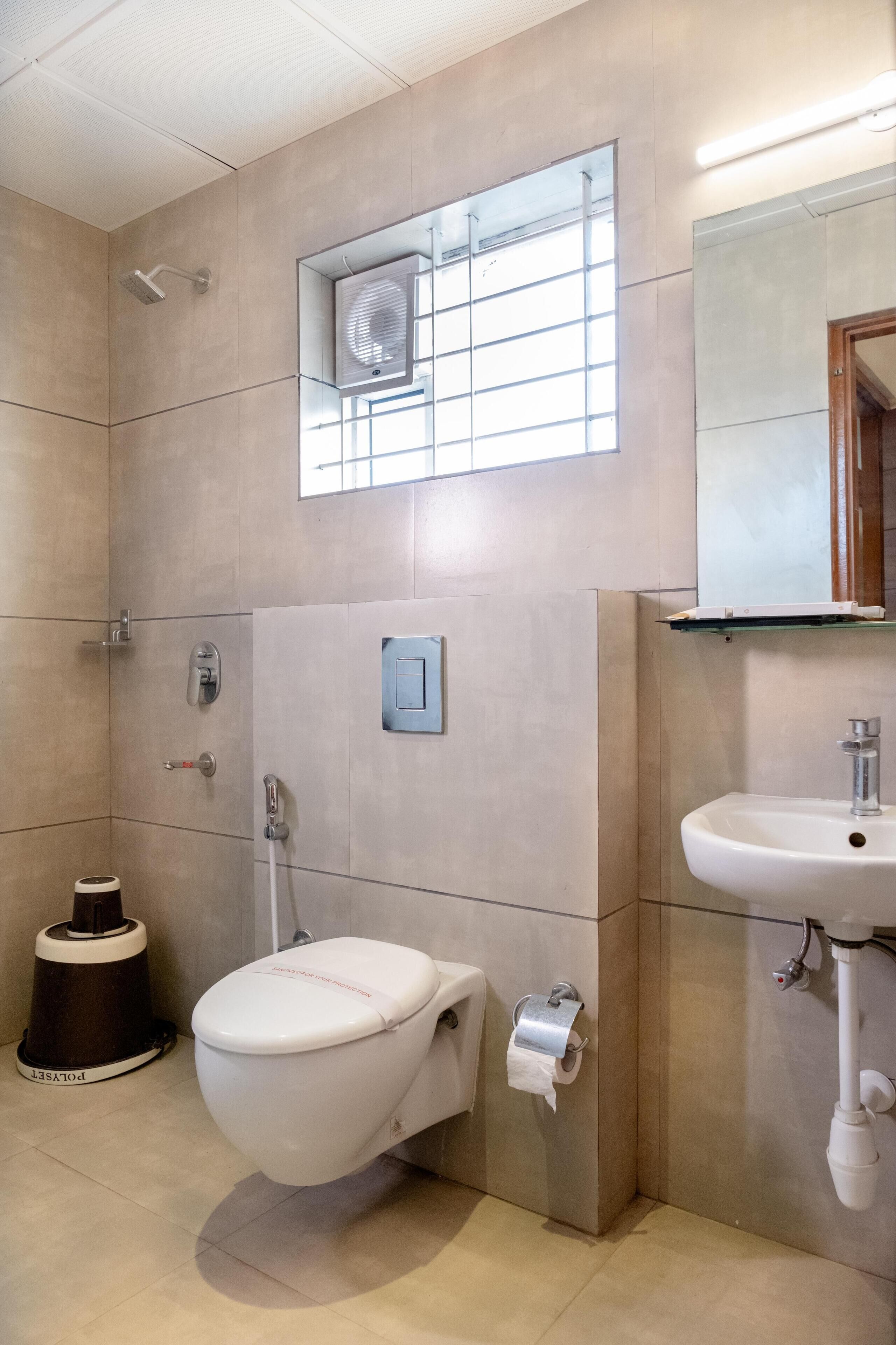 Une salle de bain avec des toilettes, un lavabo et une douche.