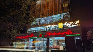 Een hotel met een bord waarop 'Hypons Hotel' en 'Aishwariya Hyper Market' staat.