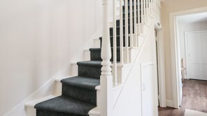 A staircase with white railings and dark steps, leading to a door. - Loubcroy Farm House (Lairg)