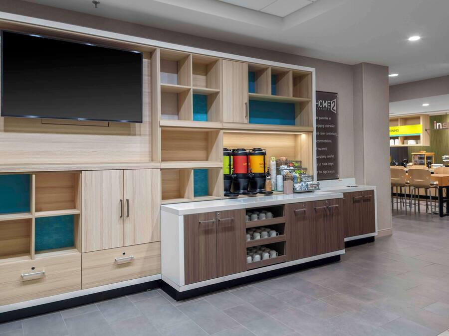 A modern kitchen with built-in cabinets, a central island, and a flat-screen TV.