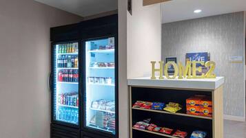 Ein Getränkeautomat mit Snacks und ein Kühlschrank voller Getränke.