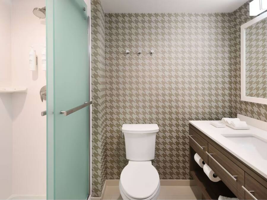 Un baño con inodoro, lavabo y ducha.