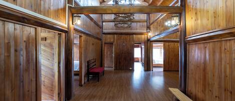 A spacious wooden interior with high ceilings and a chandelier.