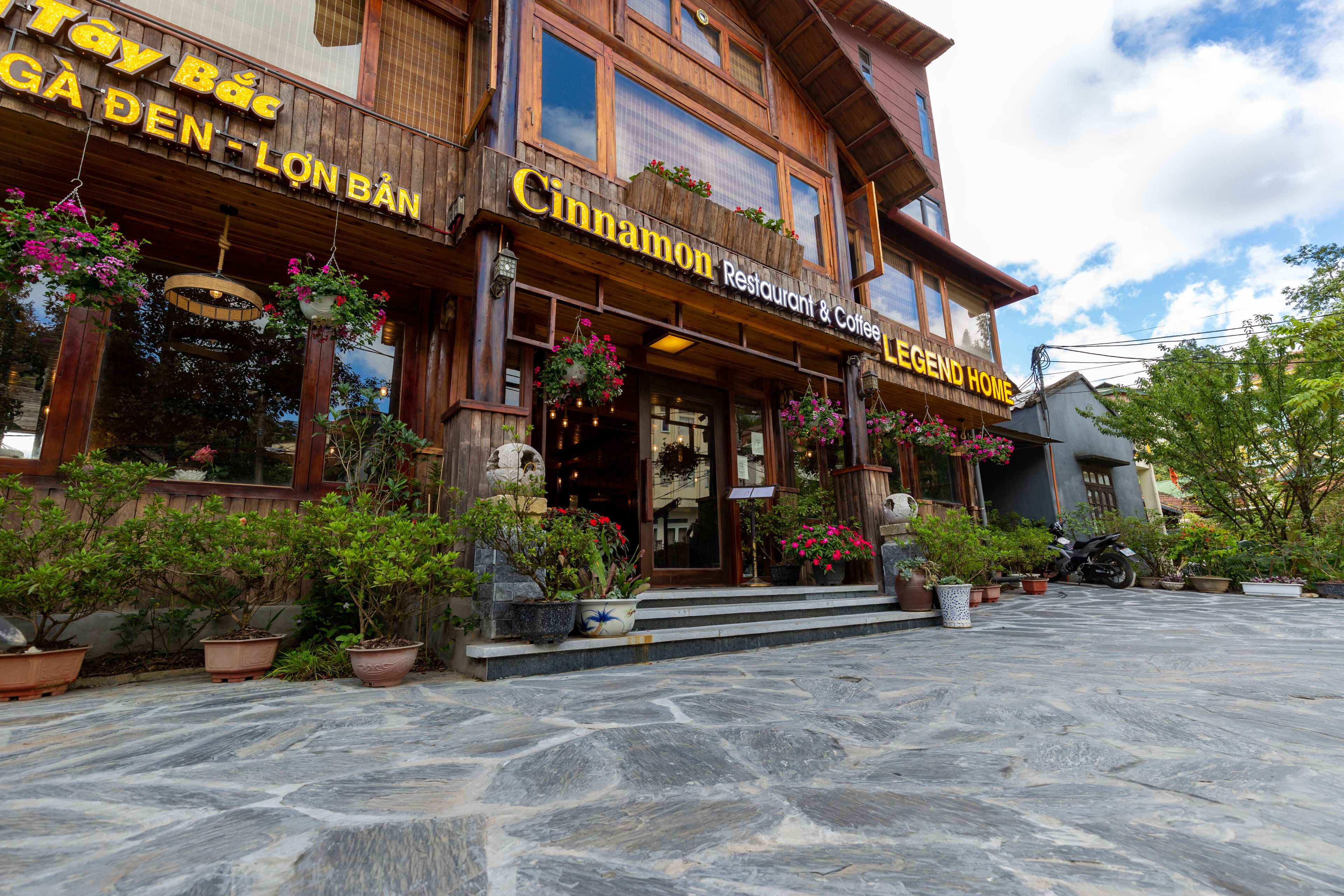 A wooden building with a sign reading "Cinnamon Restaurant & Coffee Legend Home."