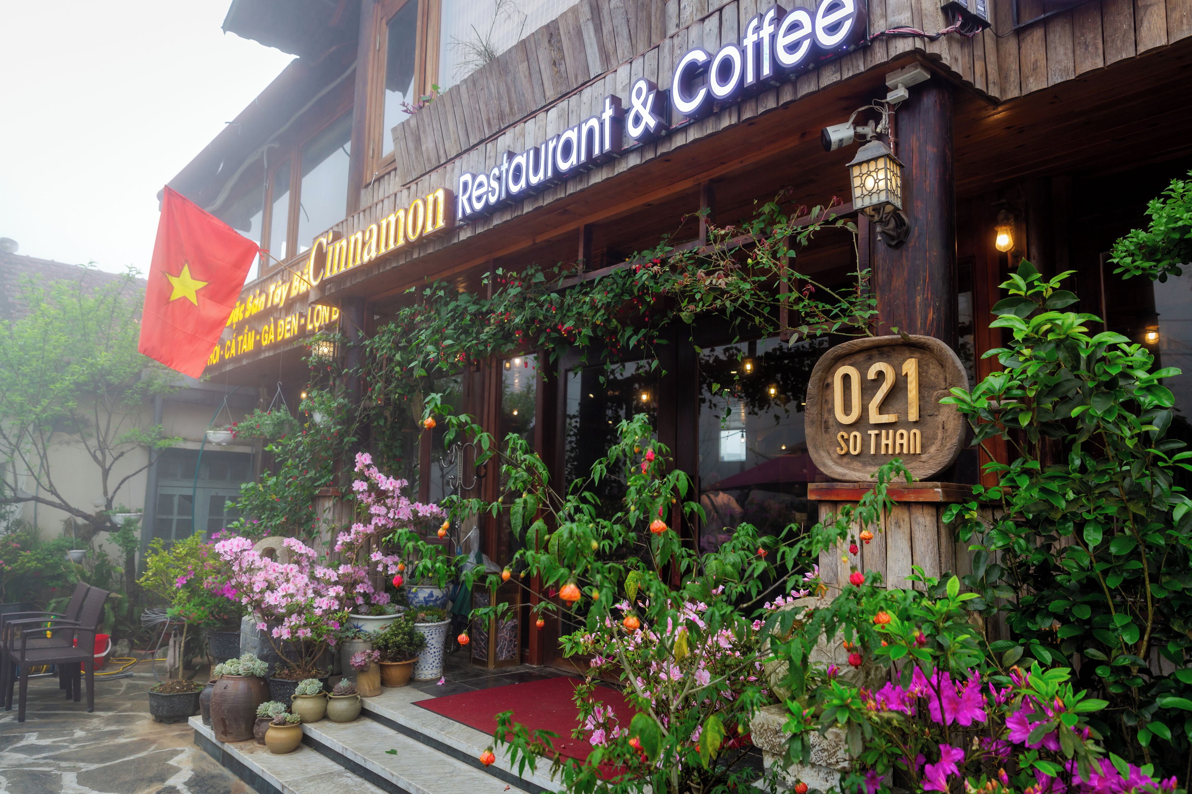 A restaurant with a wooden facade, a flag, and a sign indicating it is number 021.