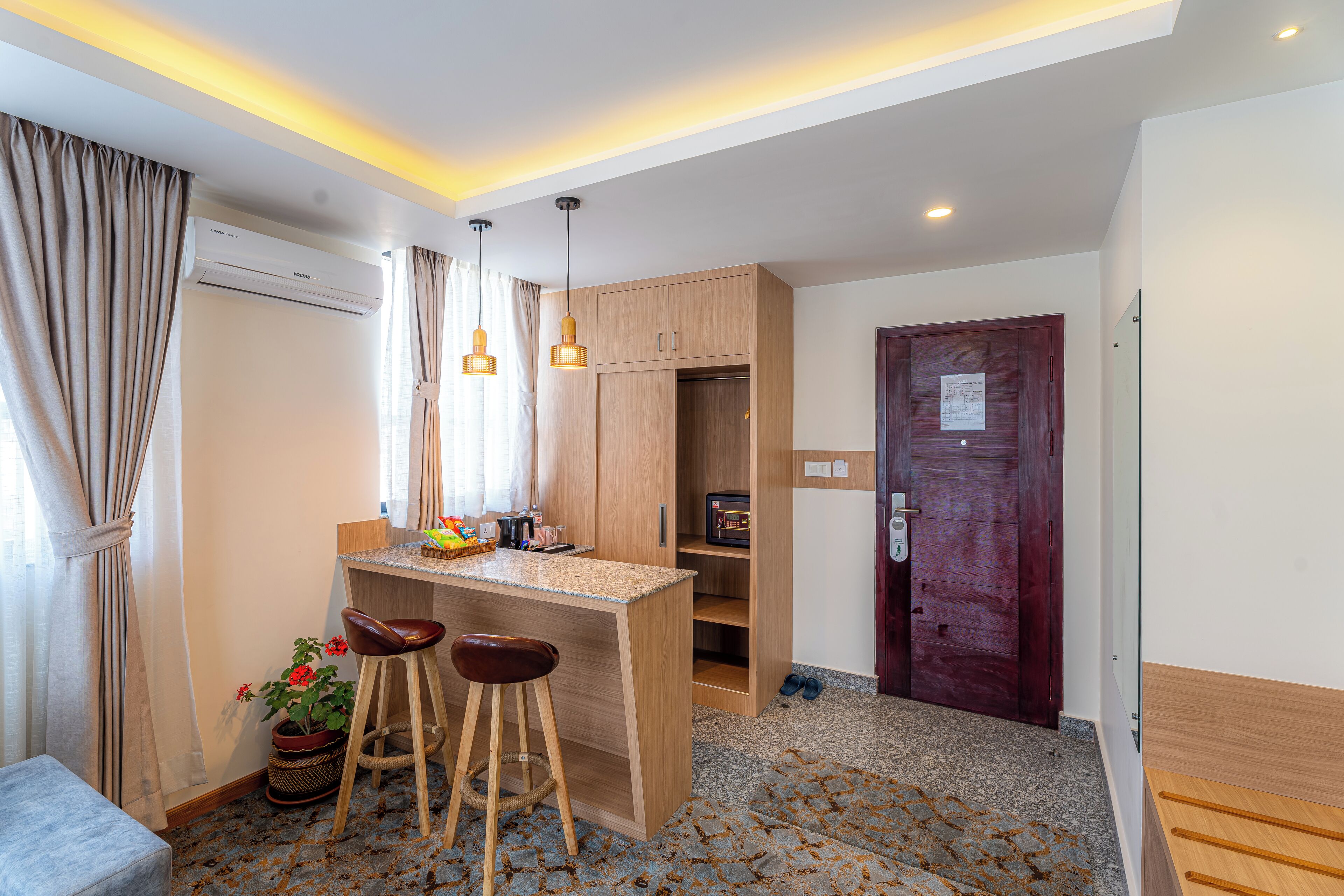 A compact kitchen with a bar area, wooden cabinets, and a small seating space.