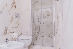 Een douche, een haardroger, een bidet, handdoeken