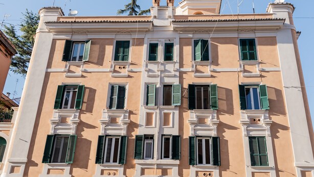 A multi-story building with a symmetrical facade, multiple windows with shutters, and satellite dishes on the roof. - Domina Apartments Roma - San Pietro 1 (Roma)
