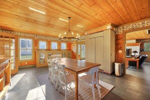 Une cuisine spacieuse avec des meubles en bois, une grande table à manger et un lustre.