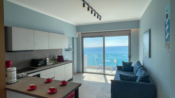 Eine moderne Küche mit Essbereich, einer Couch und Meerblick.