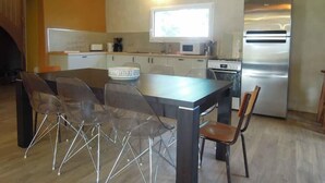 Una cucina moderna con isola centrale, sedie trasparenti ed elettrodomestici in acciaio inossidabile.