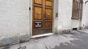 A wooden double door with a metal mail slot, a small step leading up to it, and a barred window to the right. - Casa Zamia by Mmega (Florence)