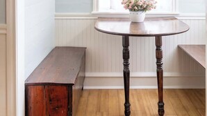 A room with a round wooden table, a bench, and a hanging light fixture. - Bridal Ready + Southern Charm | The Moli (La Grange)