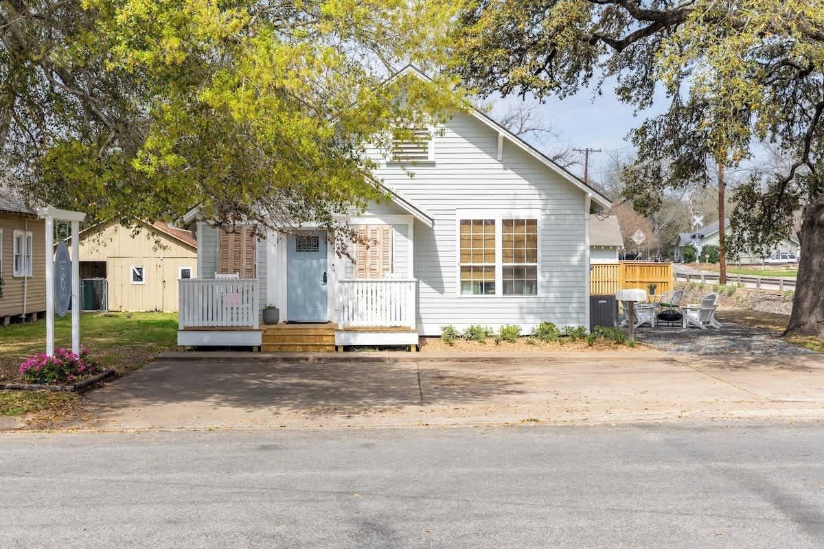 A single-story house with a front porch, a small deck, and a mailbox.