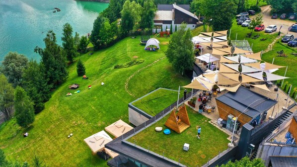 An aerial view of a property with a swimming area, a tent, and outdoor seating.