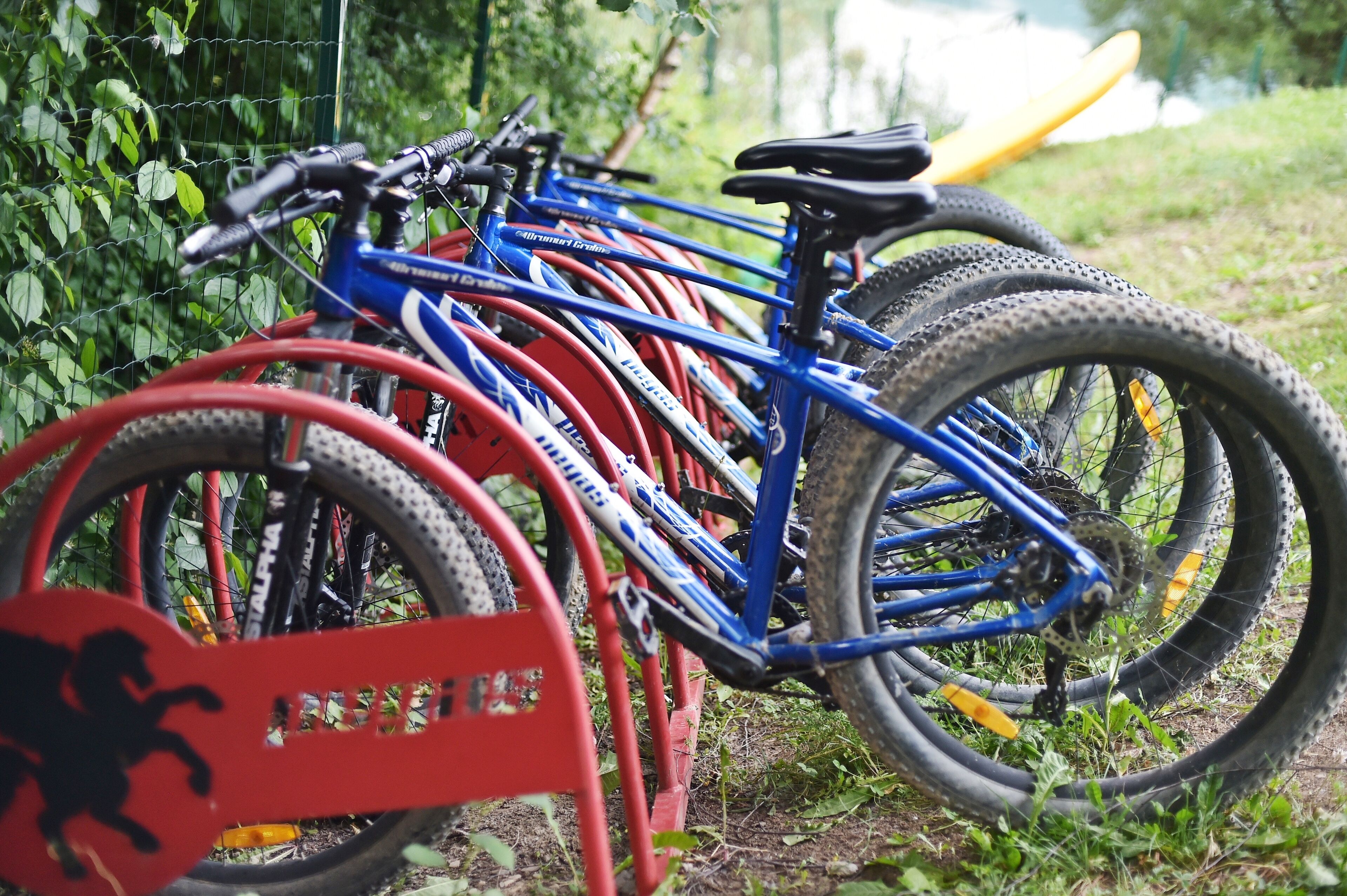 Varias bicicletas estacionadas en un aparcamiento al aire libre.