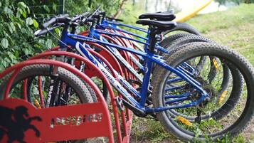 Varias bicicletas estacionadas en un aparcamiento al aire libre.