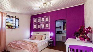 A bedroom with a bed, a small table, a chair, a desk, and a window with curtains. - Villa Bonaccorso - Il Casotto Bouganville (Viagrande)