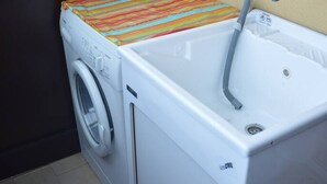 A compact laundry area with a washing machine and a sink. - Appartamento Orchidea in Residence con Piscina Condominiale (Mascali)