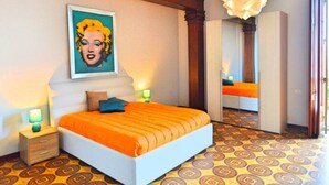 A bedroom with a large bed, a painting on the wall, a mirror, and patterned flooring. - Villa La Timpa con Jacuzzi Privata e Meravigliosa Vista Dell Etna e del Mare (Acireale)