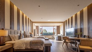 A modern hotel room with a large bed, a desk with a chair, and a TV. - Shujia wengmacuozangshidujiazhuangyuan (Deqin)