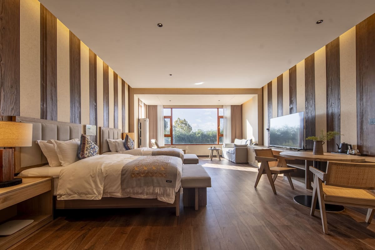 Une chambre d’hôtel moderne avec un grand lit, un bureau avec une chaise et une télévision.