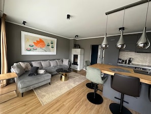 A modern living room with a grey sofa, a coffee table, and a fireplace.