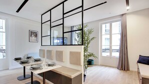 Una cocina moderna con una mesa de comedor para cuatro personas, un espejo grande y una planta en maceta.