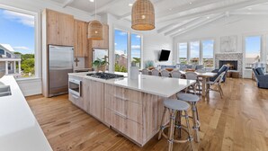 Una cocina amplia con una isla grande, armarios de madera y una estufa moderna.